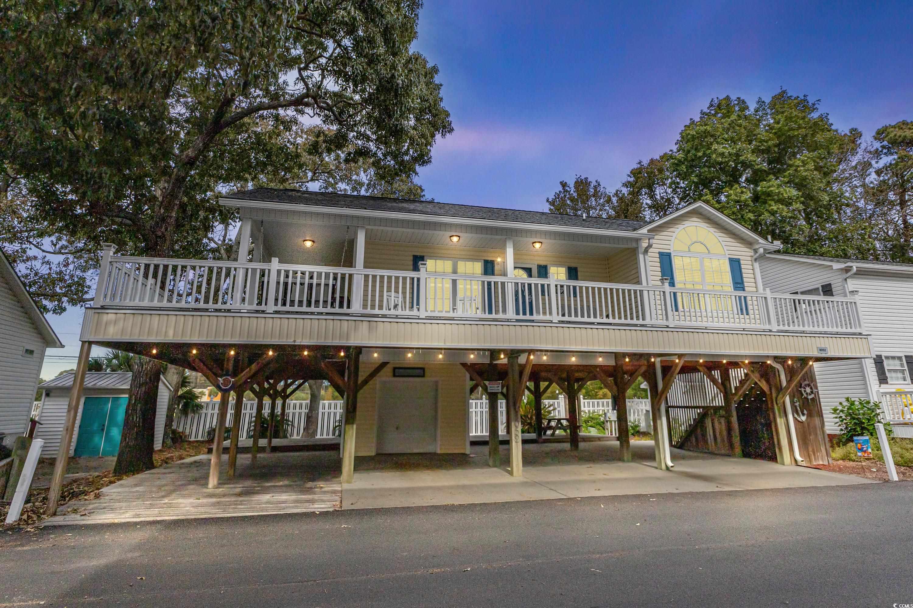 Raised beach house featuring a carport