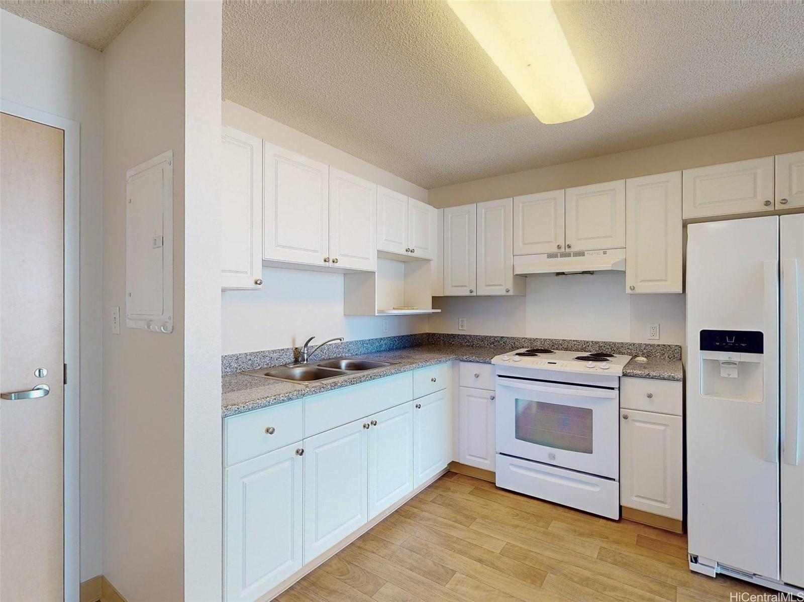 a kitchen with granite countertop white cabinets and white appliances