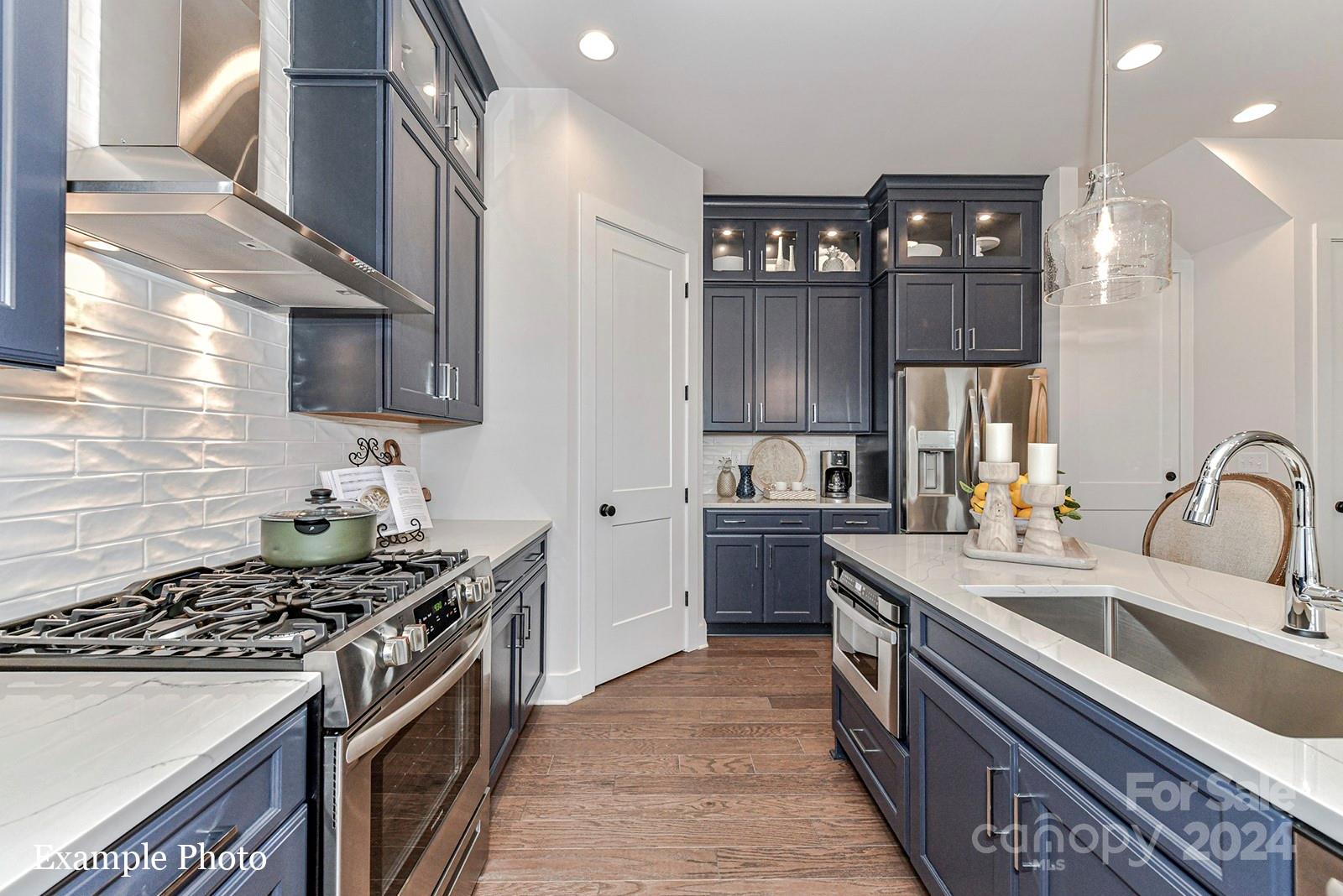 a kitchen with a stove sink and cabinets