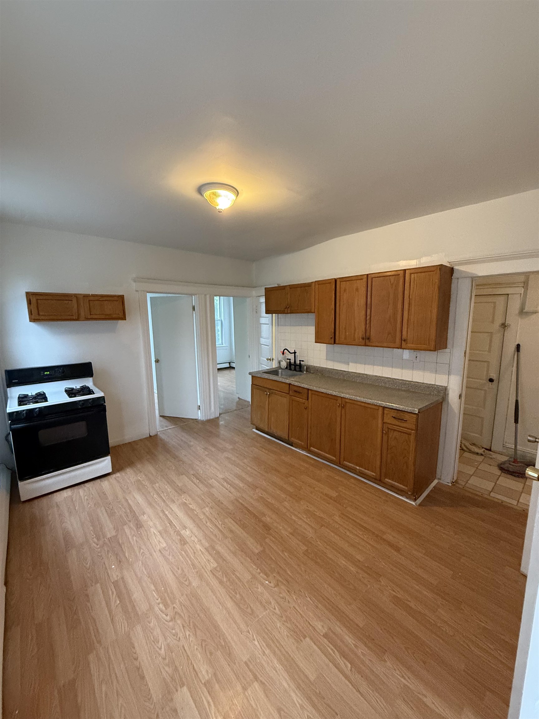 a room with a bed and a view of kitchen