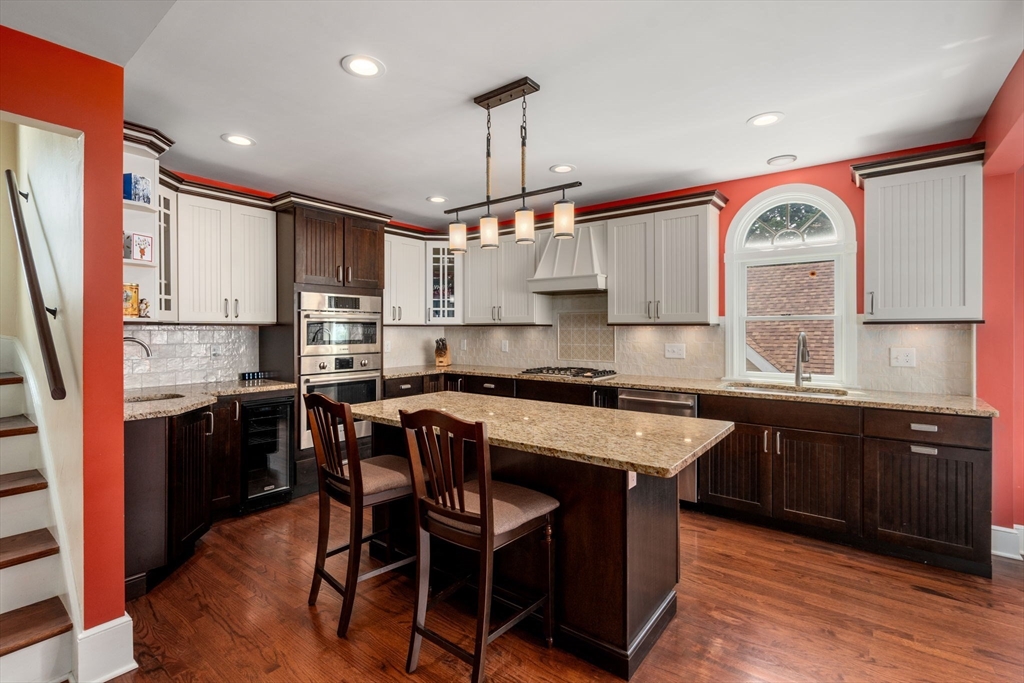 a kitchen with a sink a center island cabinets and stainless steel appliances