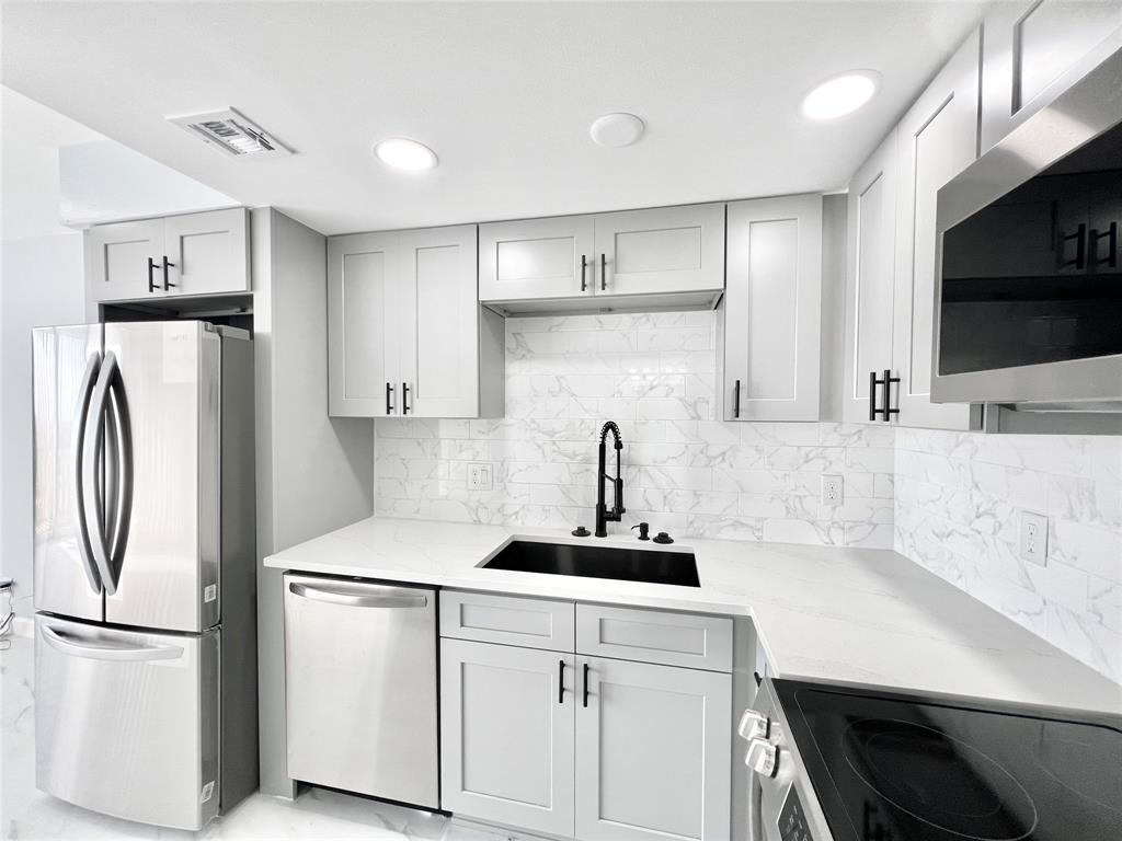 a kitchen with stainless steel appliances a refrigerator and a stove top oven