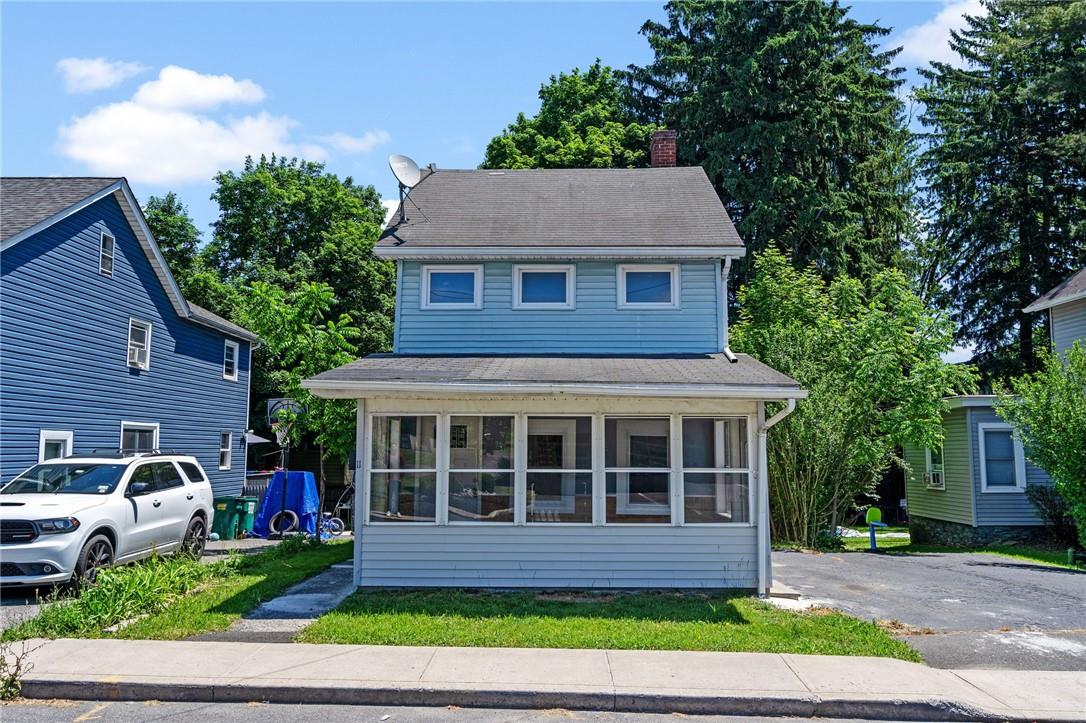 View of front of property featuring a front yard and a sunroom