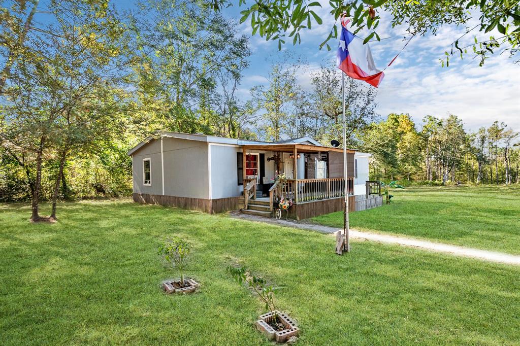 a view of a house with backyard and trees