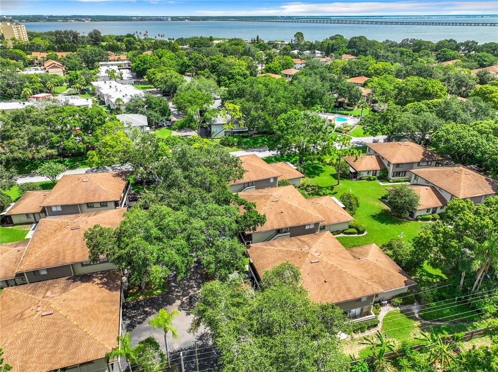 an aerial view of residential house with outdoor space and trees all around