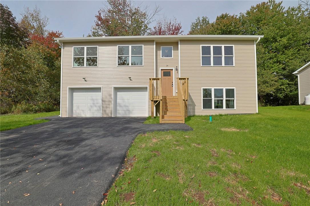 Split foyer home with a garage and a front yard