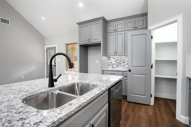 a kitchen with kitchen island granite countertop a sink stove and refrigerator