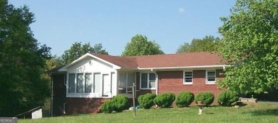 a front view of a house with a yard and trees