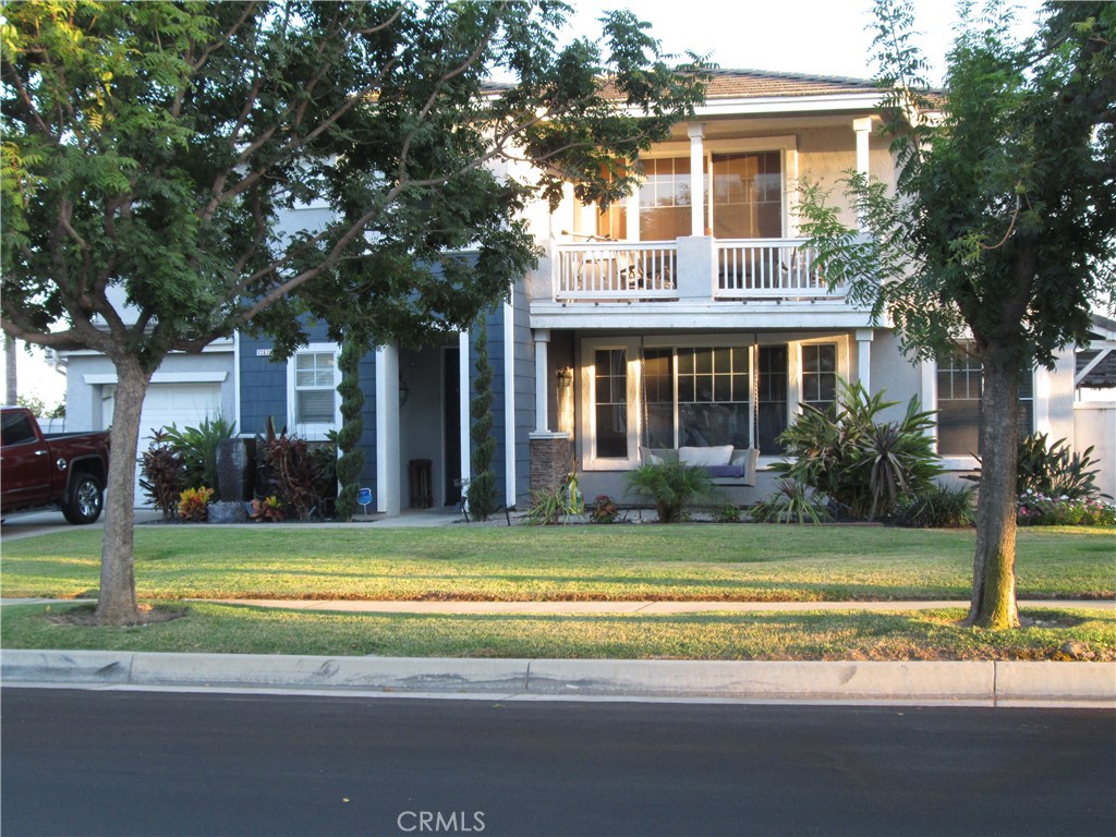 a view of a house with a big yard and palm trees