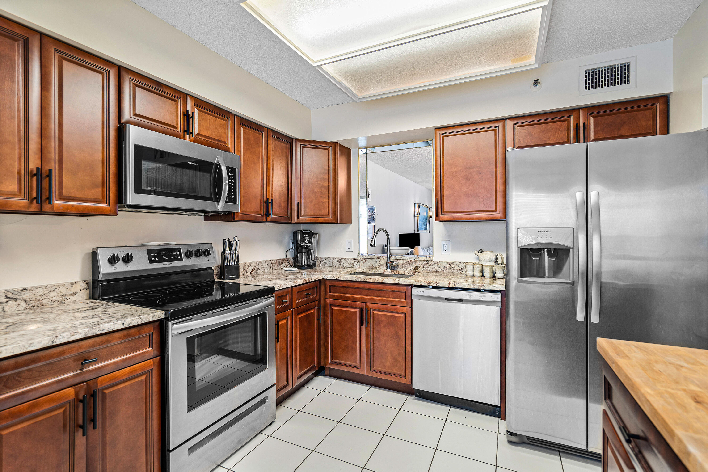 a kitchen with stainless steel appliances granite countertop a stove top oven a sink and dishwasher