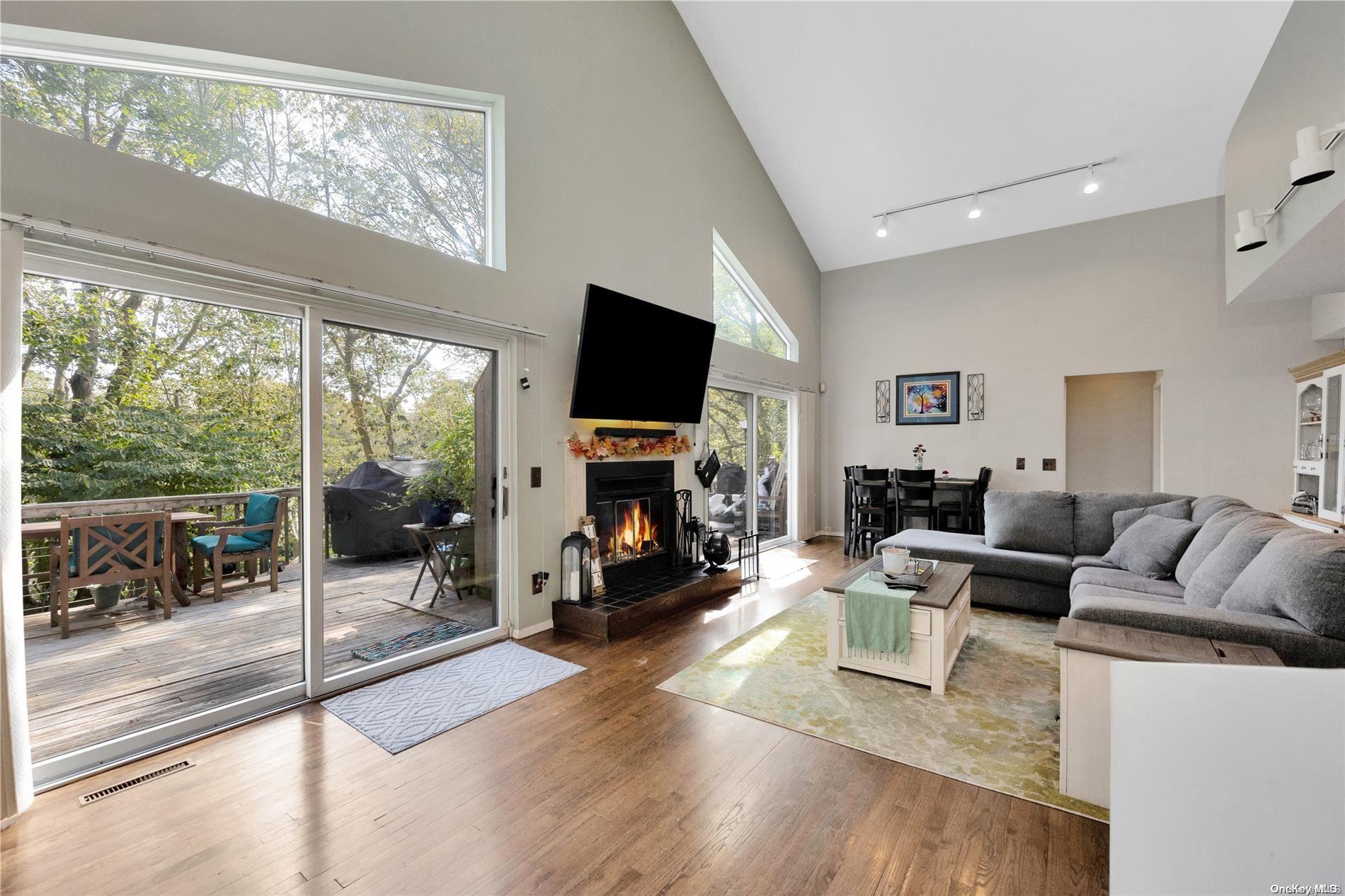 a living room with furniture a large window and a flat screen tv