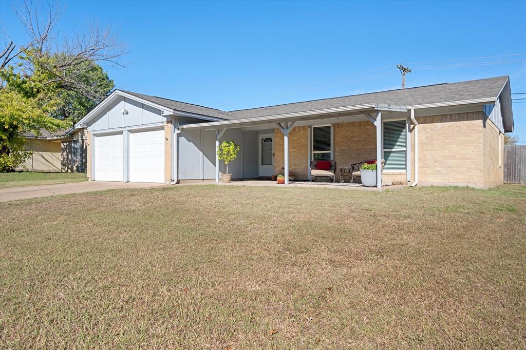 a view of a house with a patio and a yard