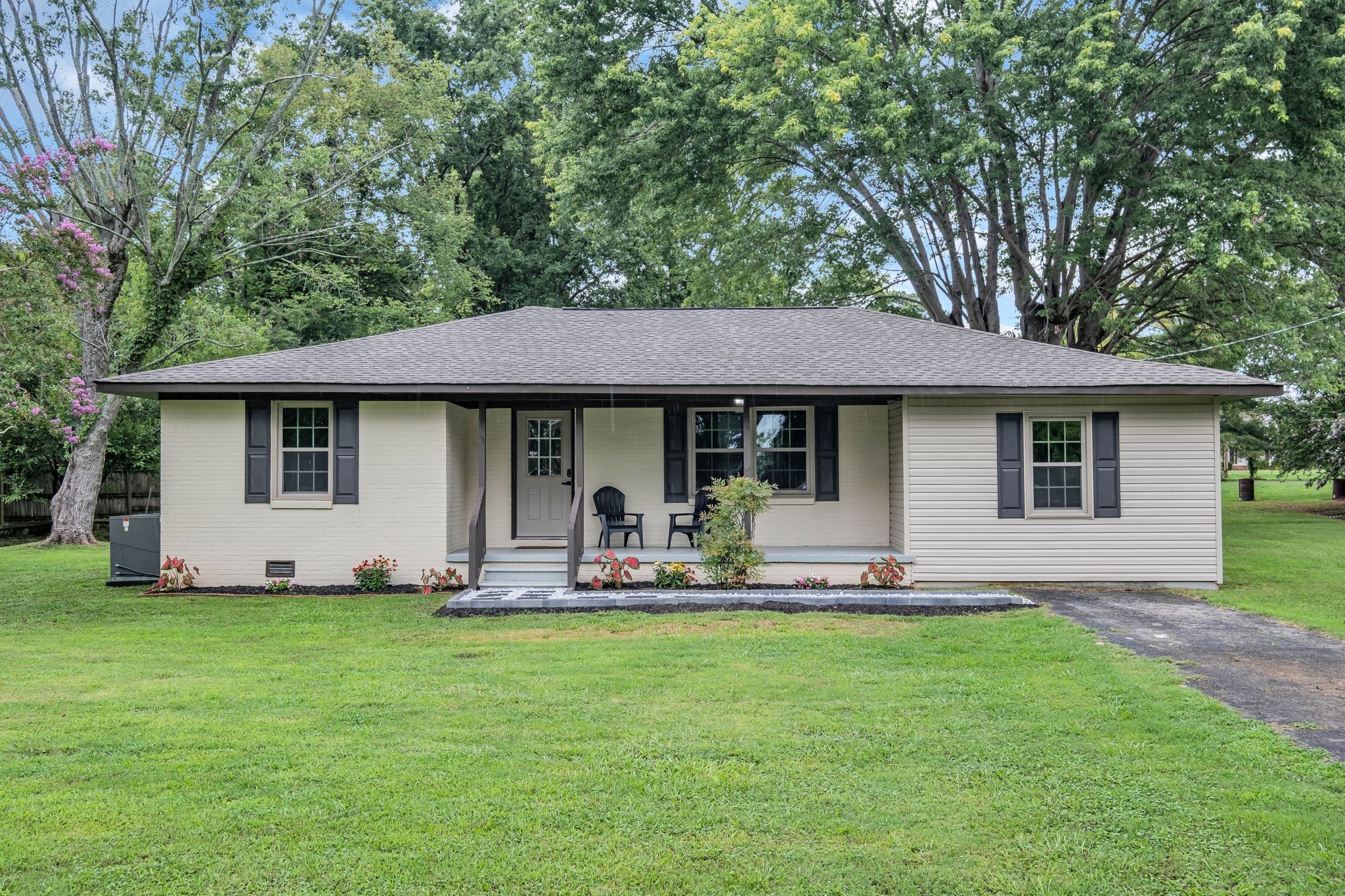 a front view of a house with a garden and sitting area