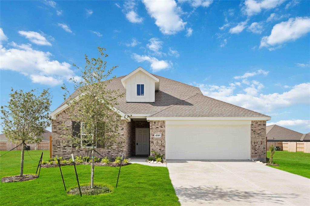 a front view of a house with a yard and green space