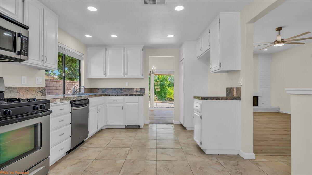 a kitchen with a stove top oven a sink dishwasher and a refrigerator with wooden floor