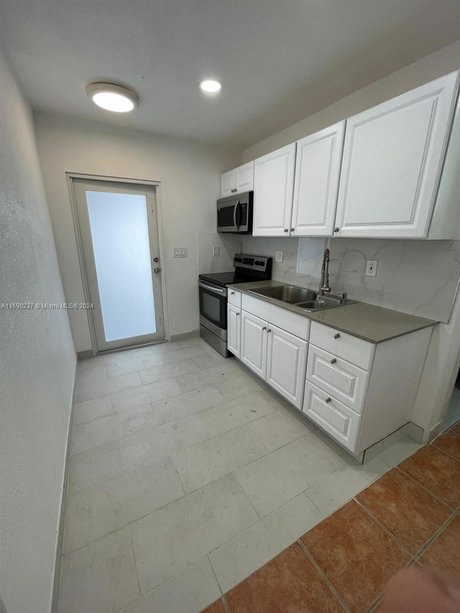 a kitchen with stainless steel appliances granite countertop a sink and cabinets