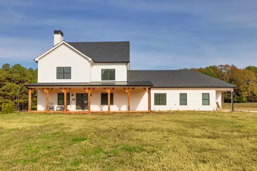 a front view of house with yard and trees in the background