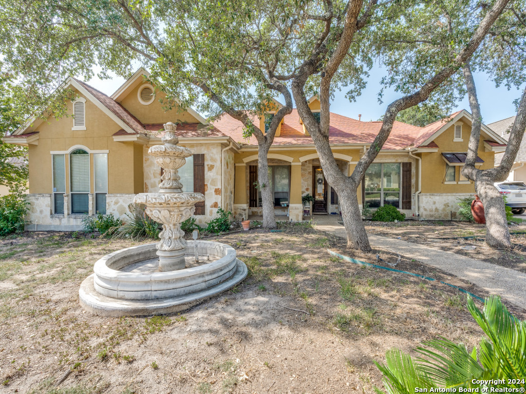 a view of a house with a fountain and a tree