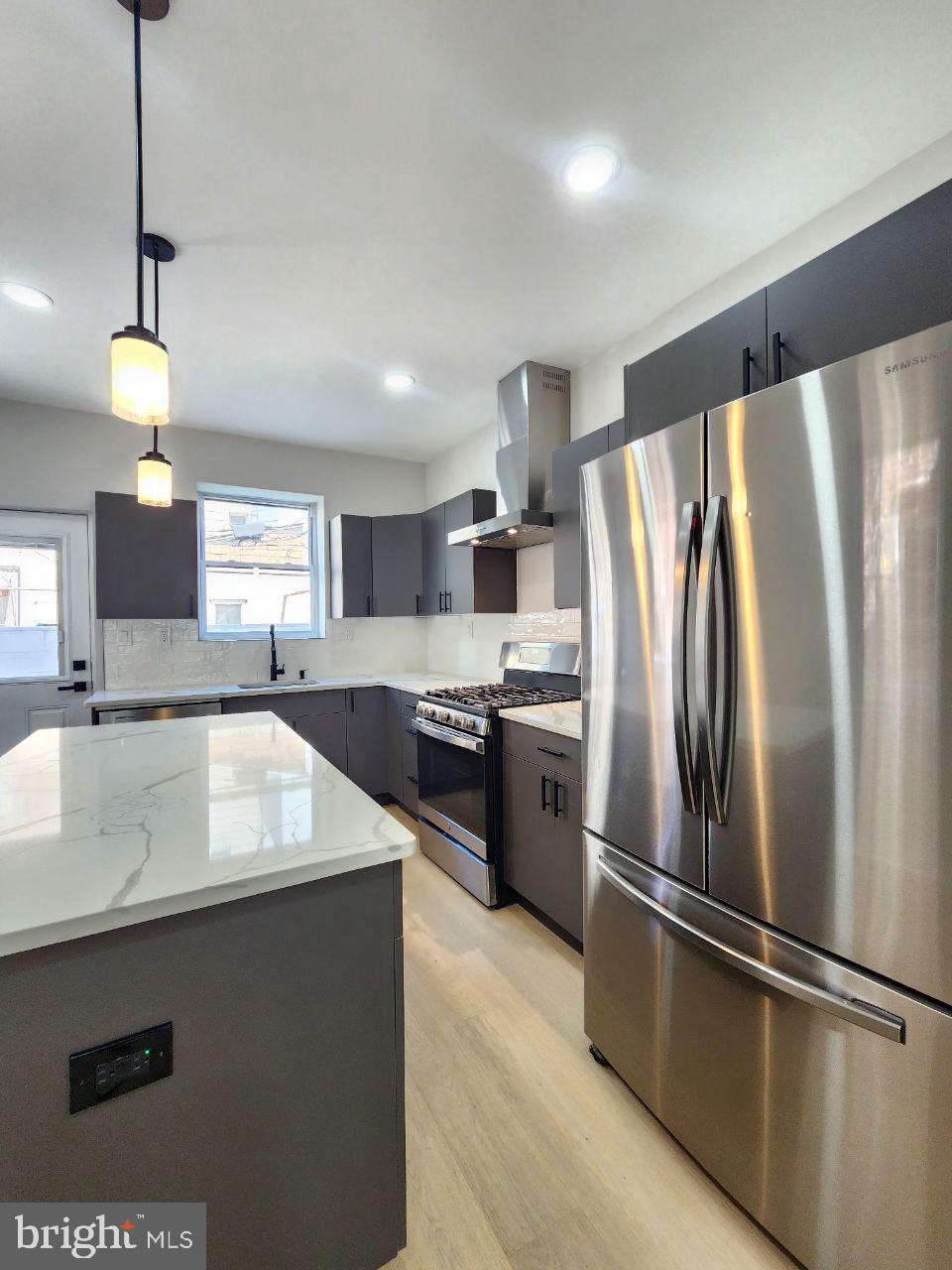 a kitchen with stainless steel appliances granite countertop a refrigerator a sink and a stove