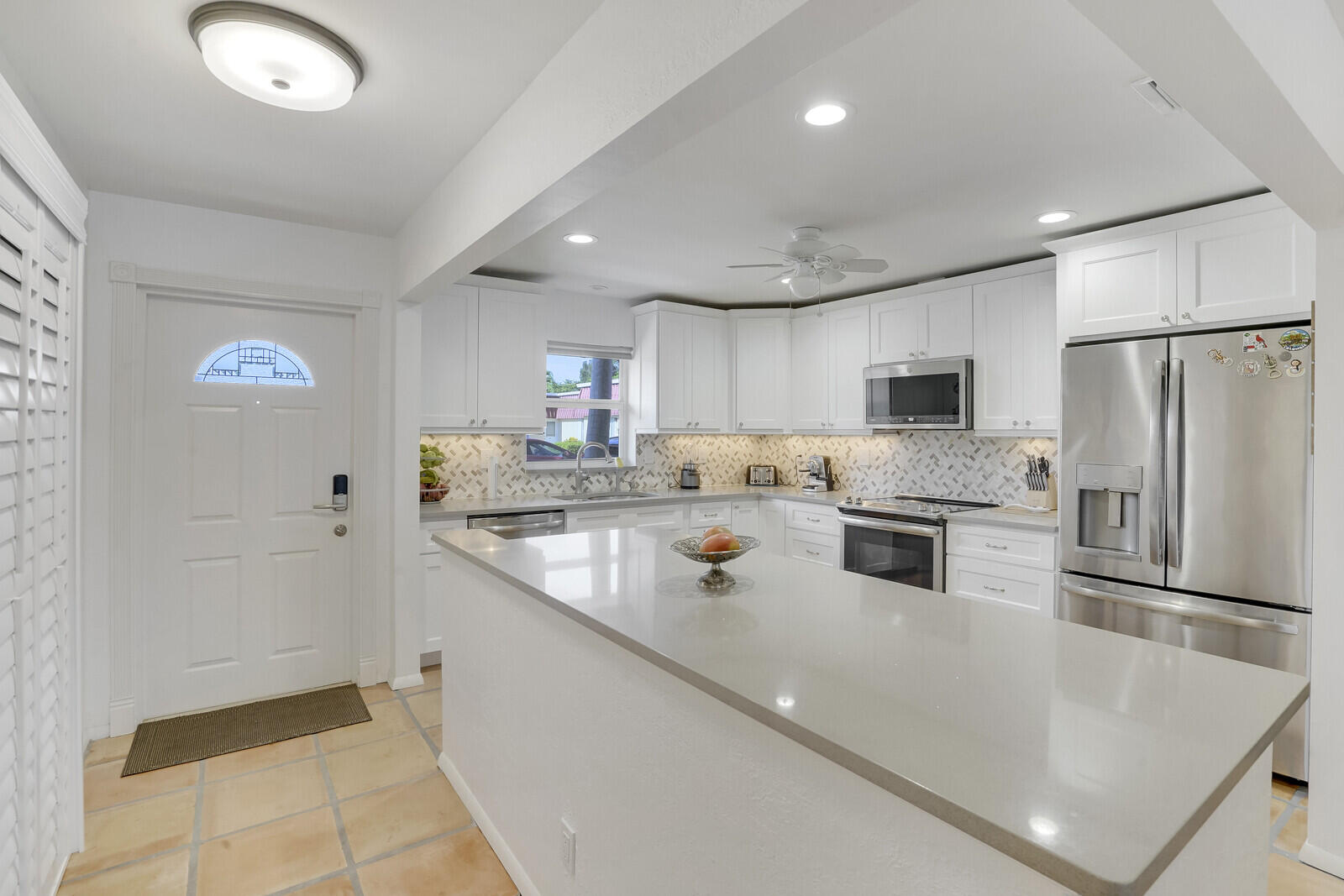 a kitchen with stainless steel appliances a refrigerator sink and microwave