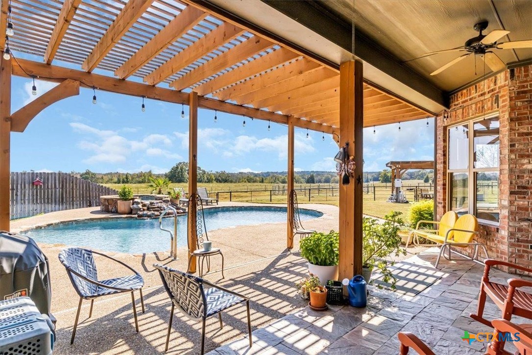 a view of swimming pool with an outdoor seating space