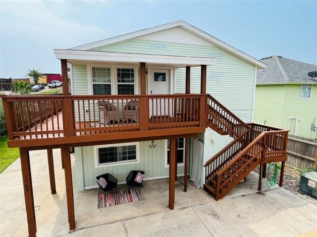 a view of a house with wooden deck and furniture