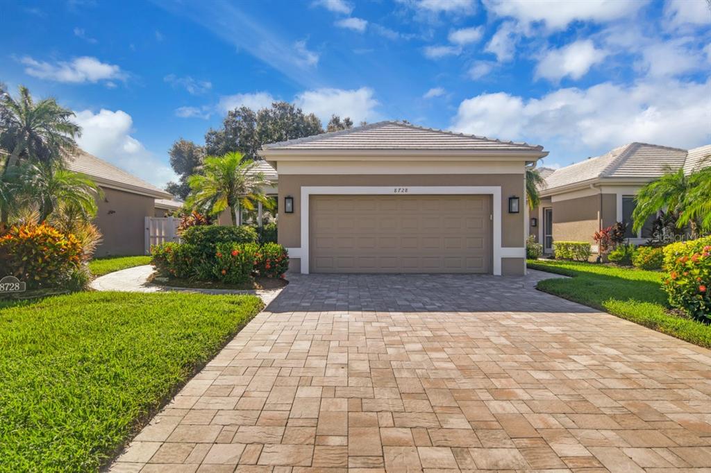 a front view of a house with a yard and a garage