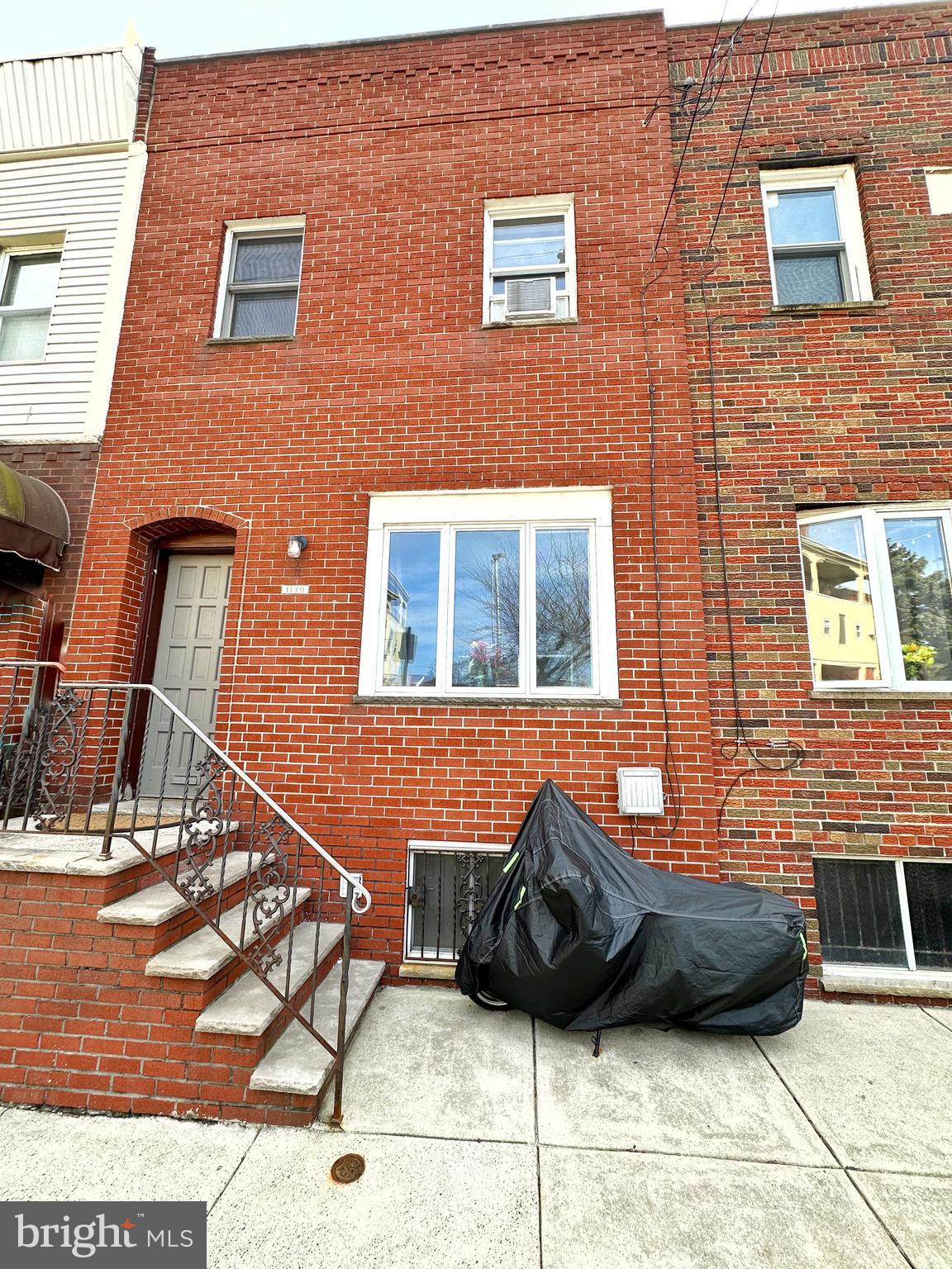 a view of a brick house with car parked