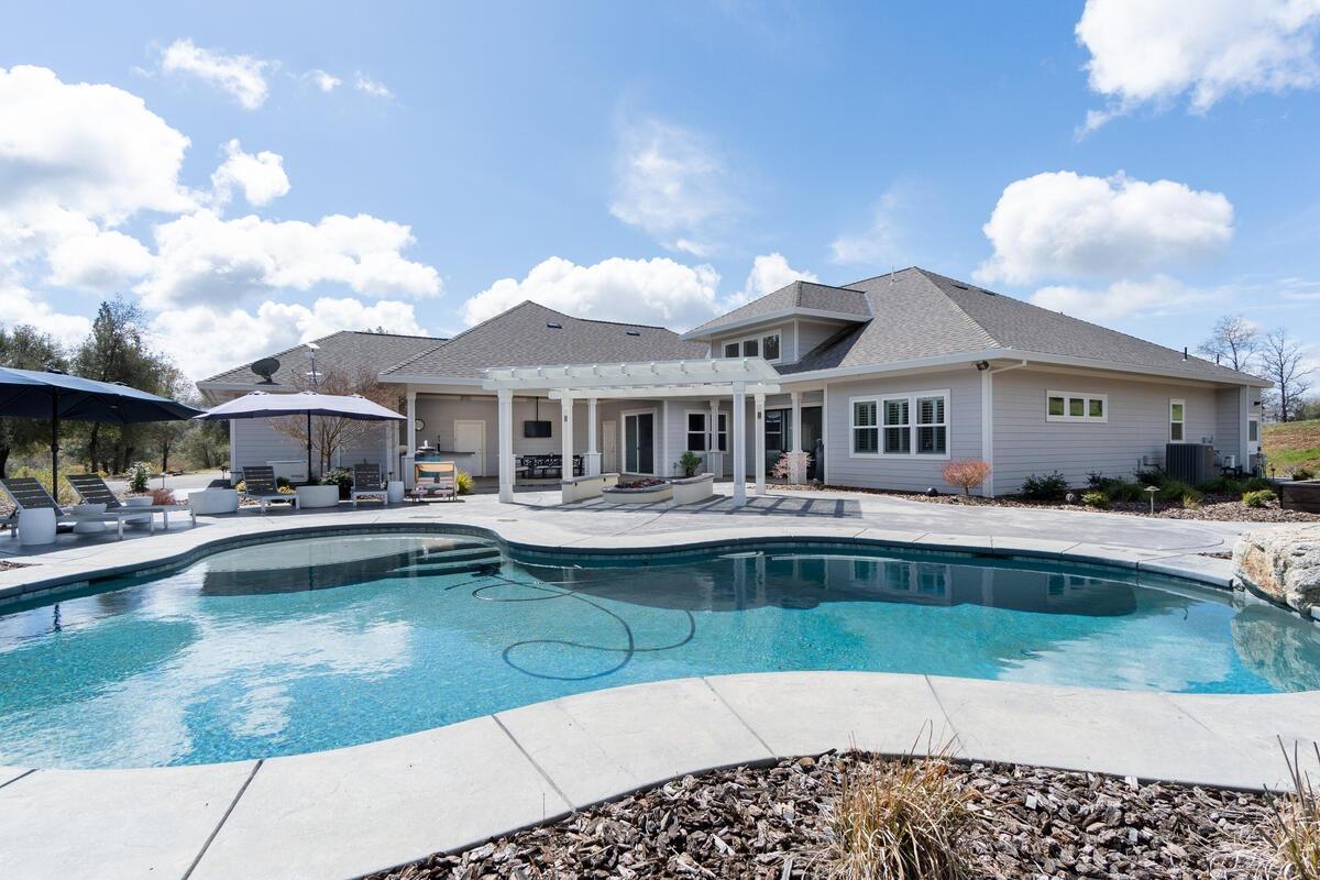 a front view of a house with swimming pool having outdoor seating