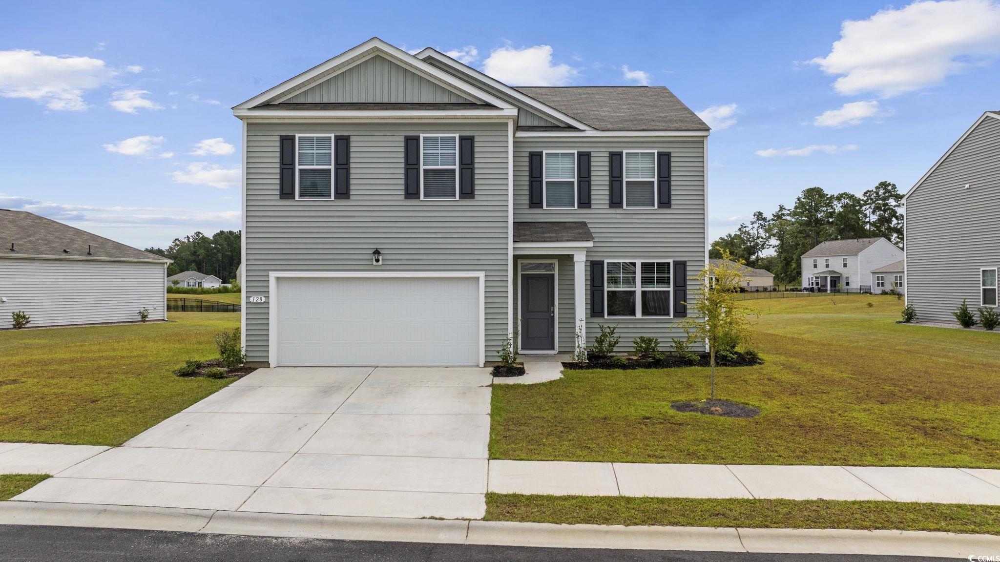 View of front of home with a garage and a front la