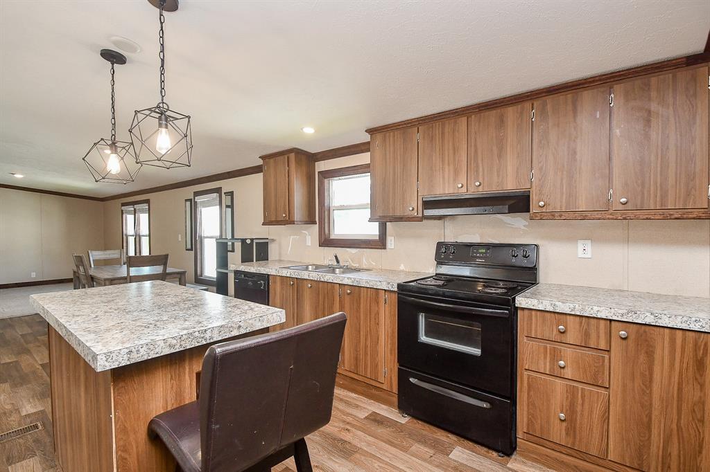 a kitchen with stainless steel appliances granite countertop wooden cabinets a stove a sink and dishwasher