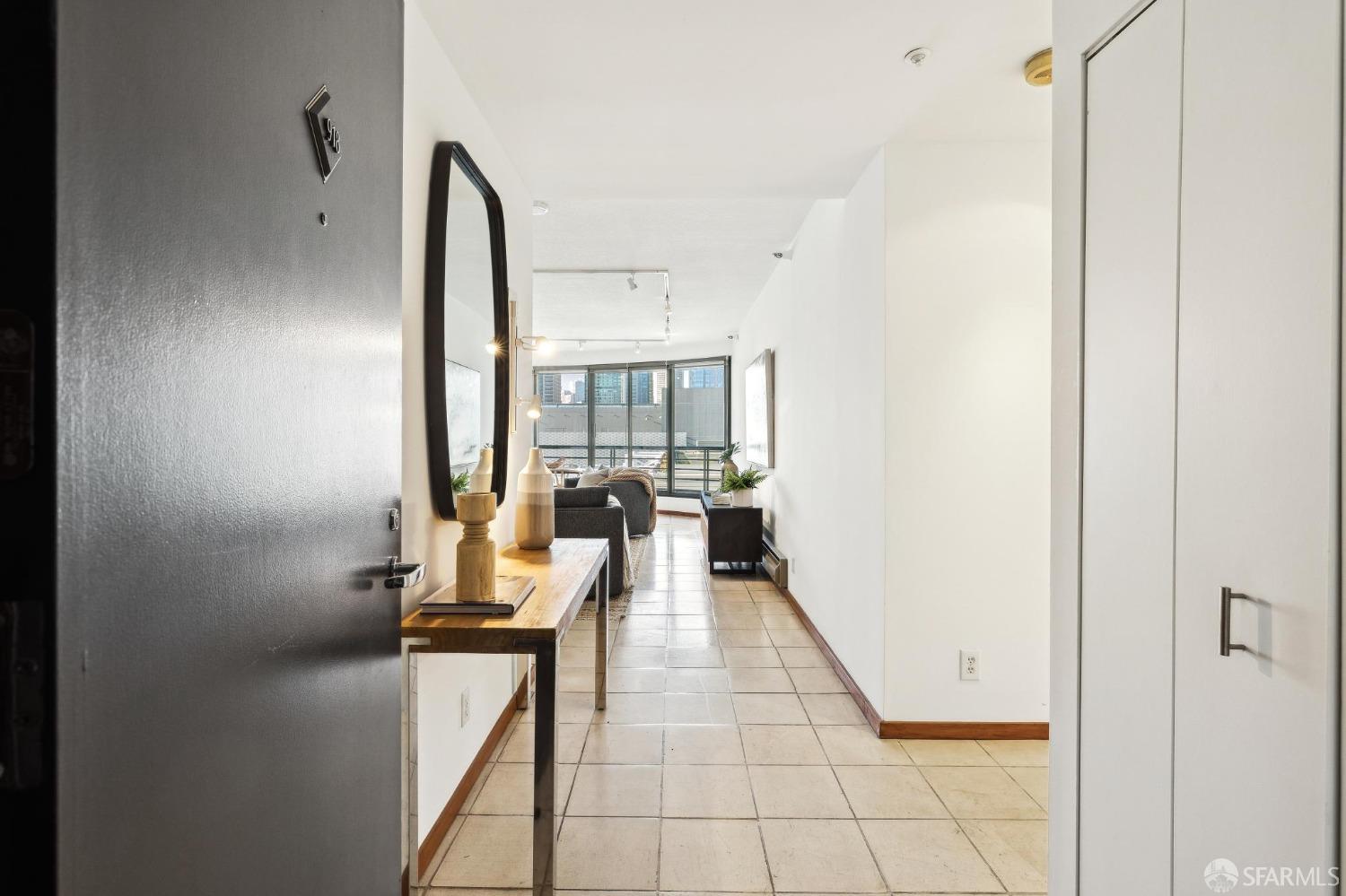 a view of a hallway with furniture and floor to ceiling window