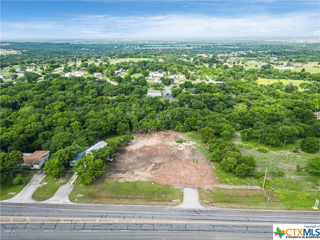 an aerial view of residential houses with outdoor space and trees