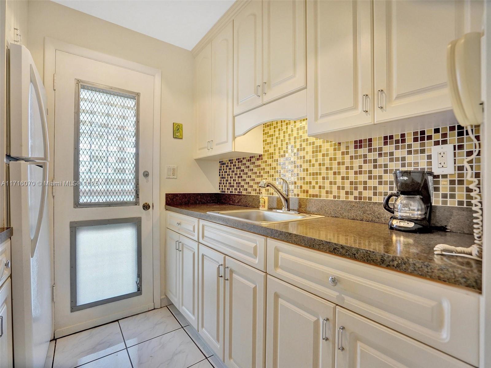 a kitchen with granite countertop white cabinets and white appliances