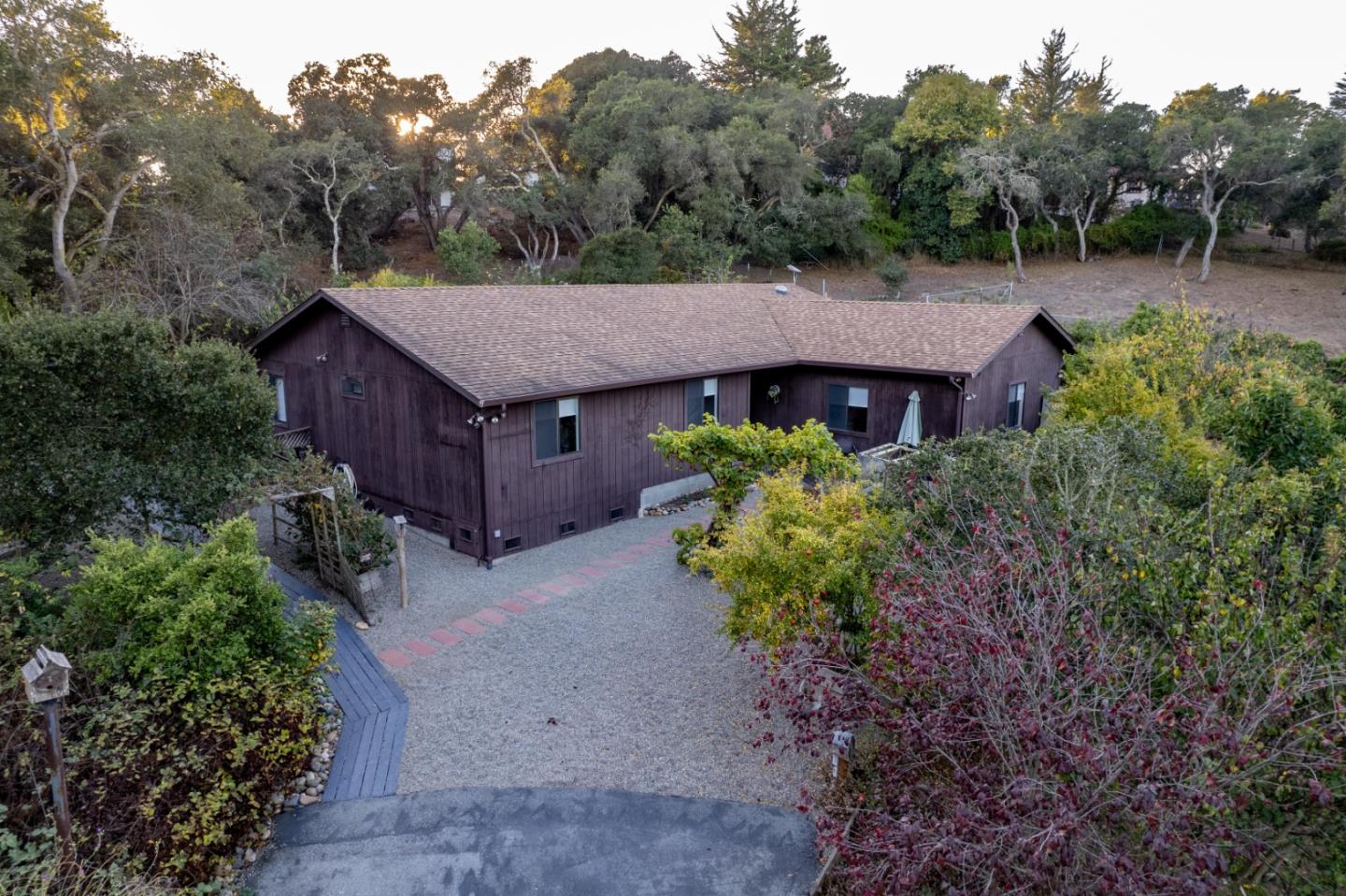 a aerial view of a house with a yard and large trees