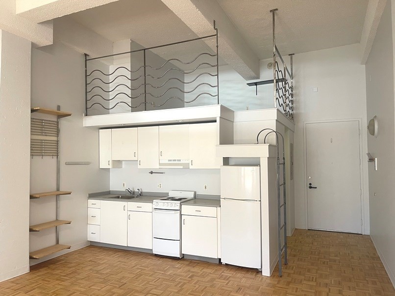 a kitchen with a refrigerator and white cabinets