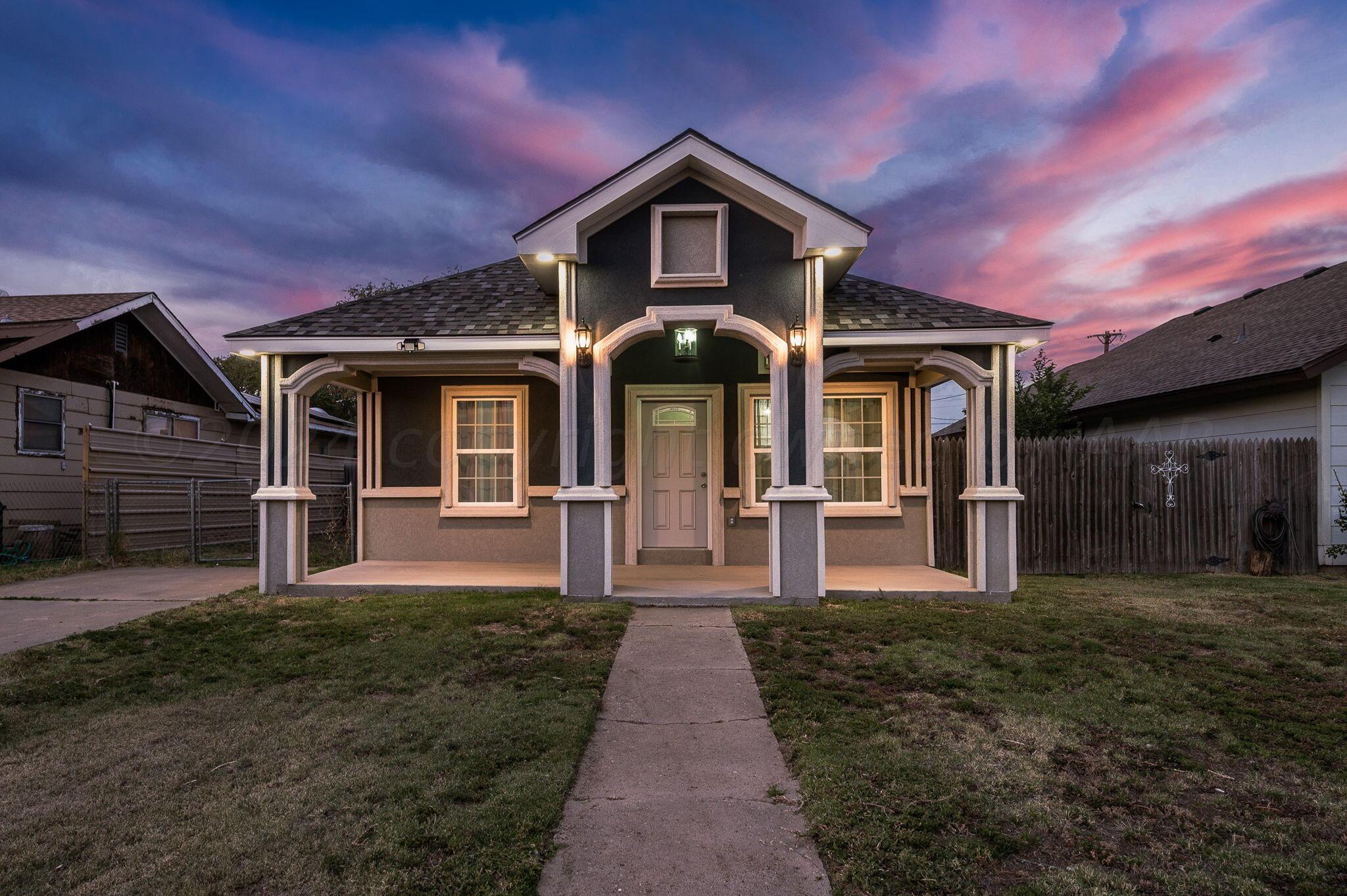 a front view of a house with yard and green space