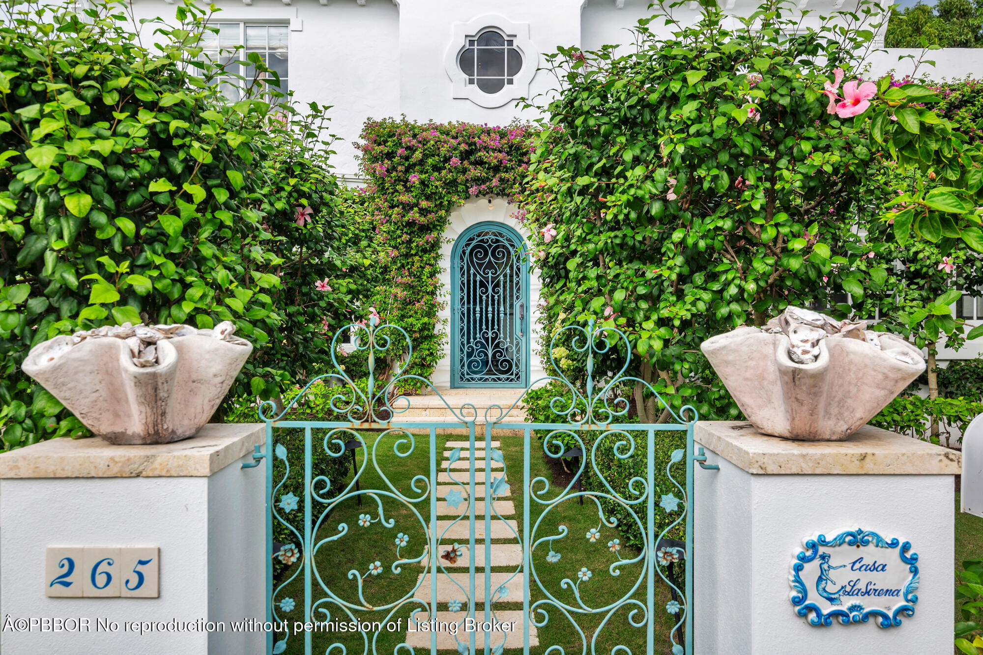 a view of a door of the house with potted plants