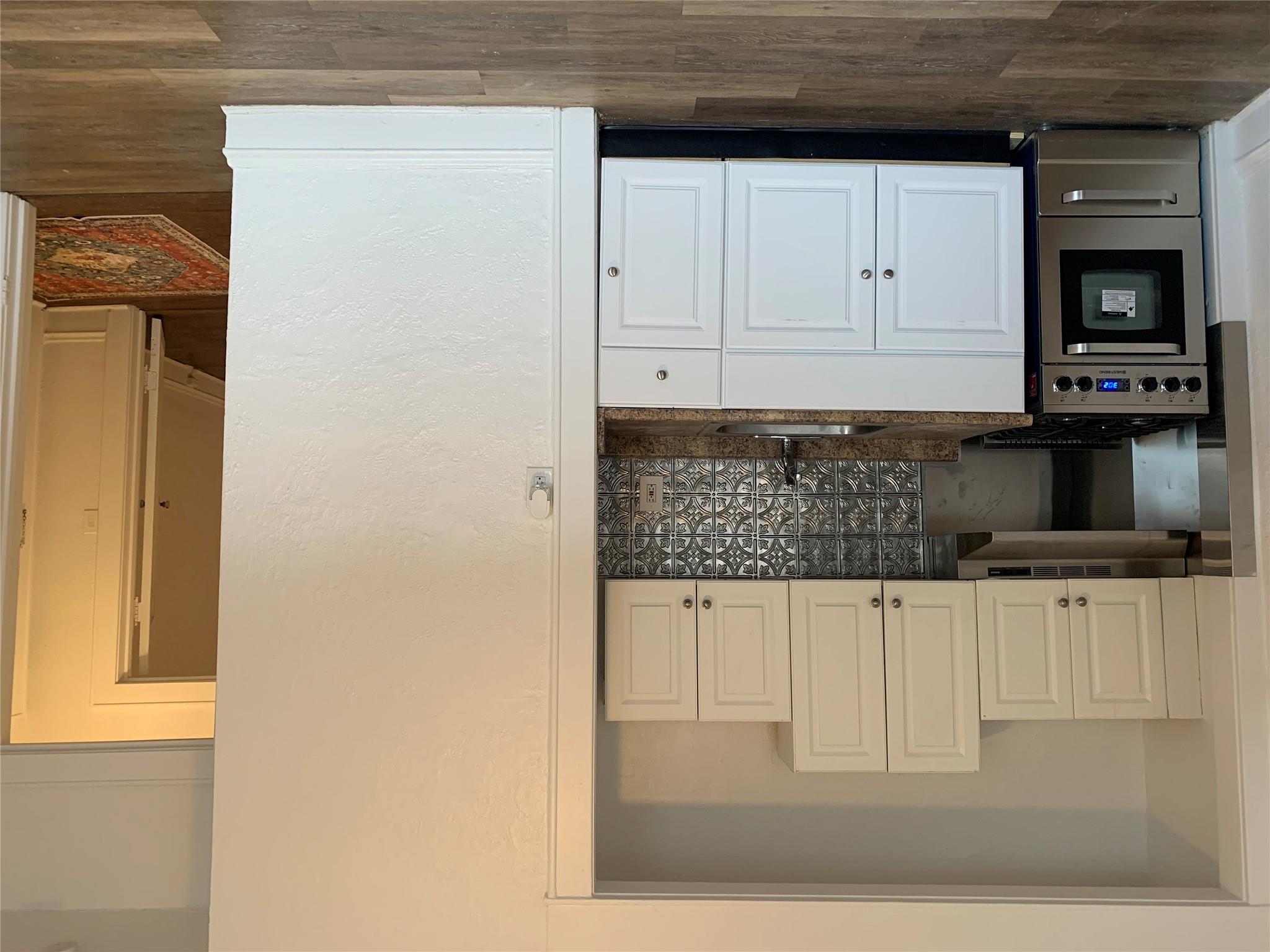 a kitchen with granite countertop white cabinets and stainless steel appliances