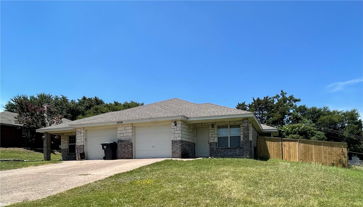 a view of a house with a yard and a garage