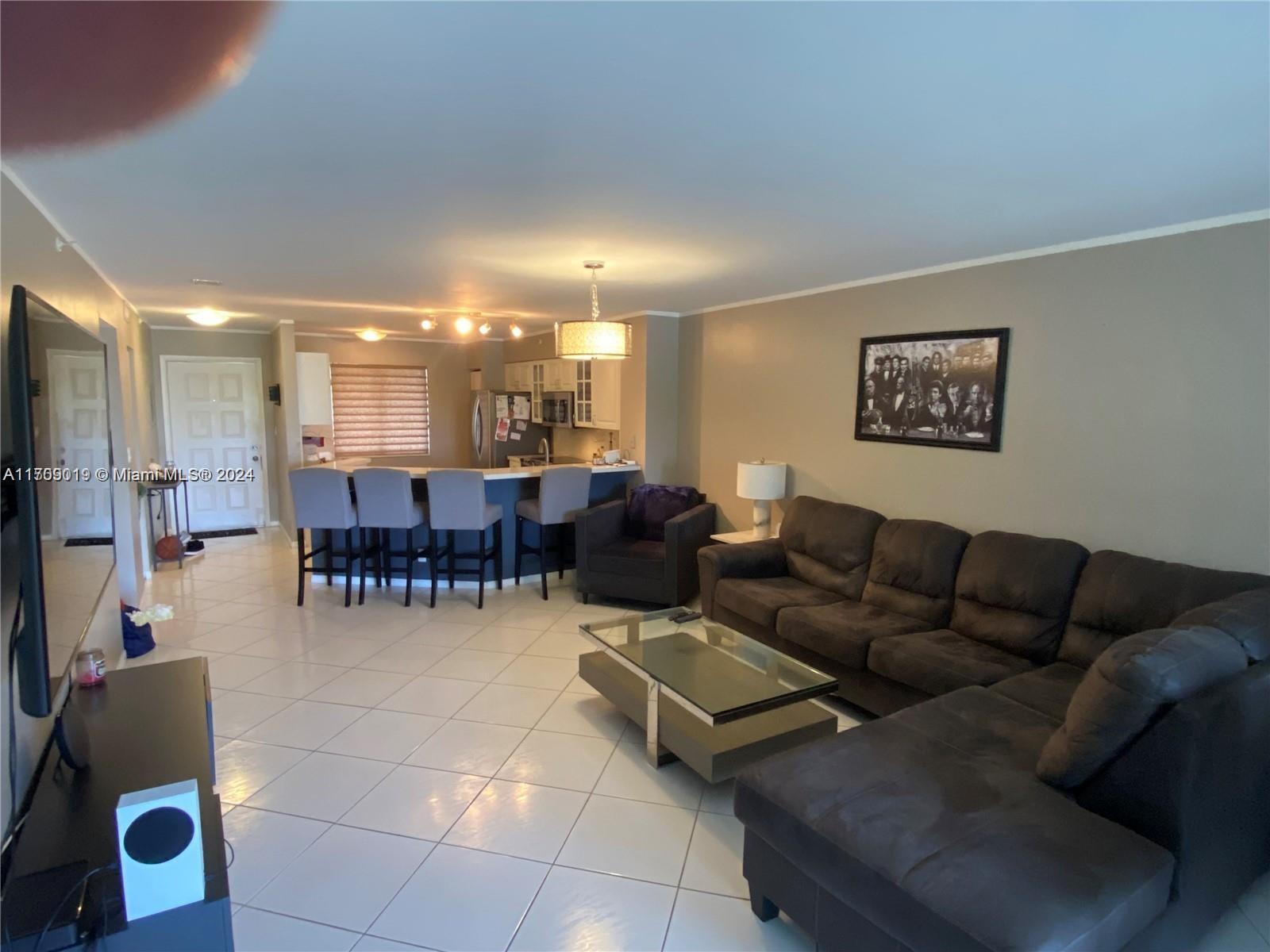 a living room with furniture and a dining table with kitchen view