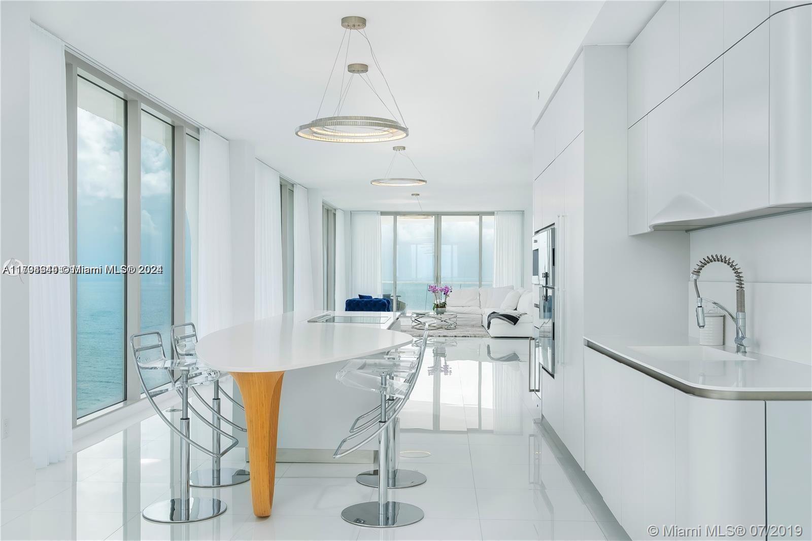 a view of a kitchen with kitchen island dining table and stainless steel appliances