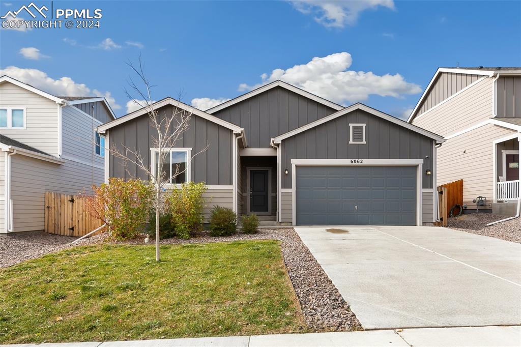 View of front of property featuring a garage and a front lawn