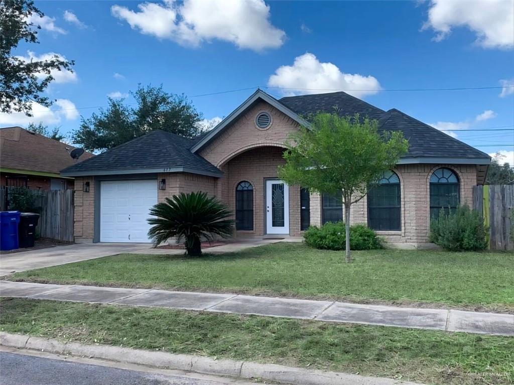 View of front of property with a garage and a front lawn