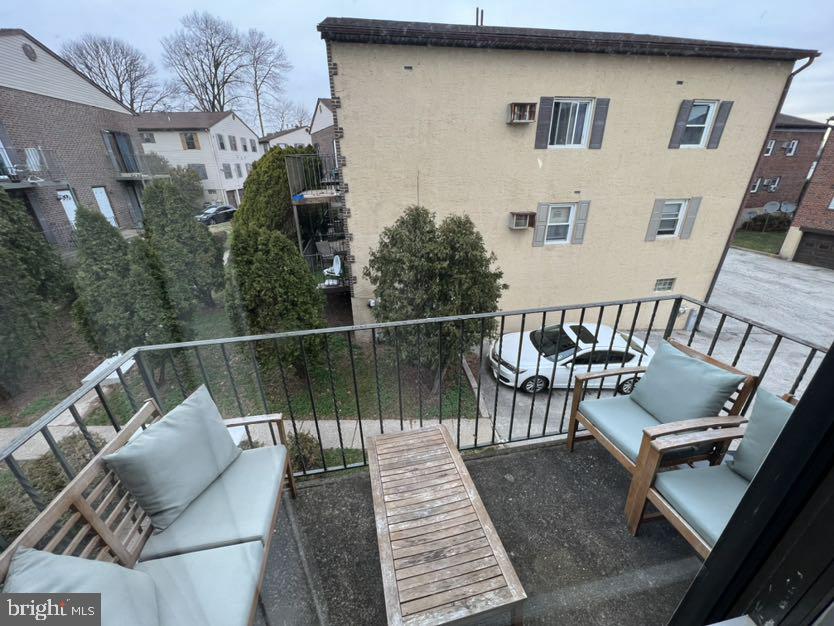 a balcony with wooden floor and glass top table