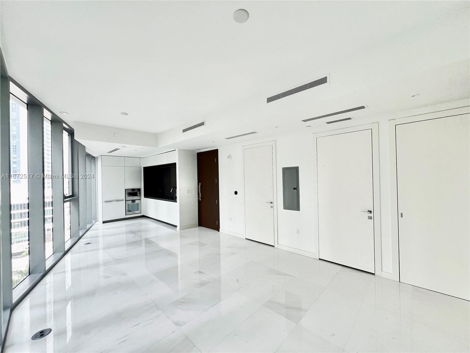 a view of a big room with windows and chandelier