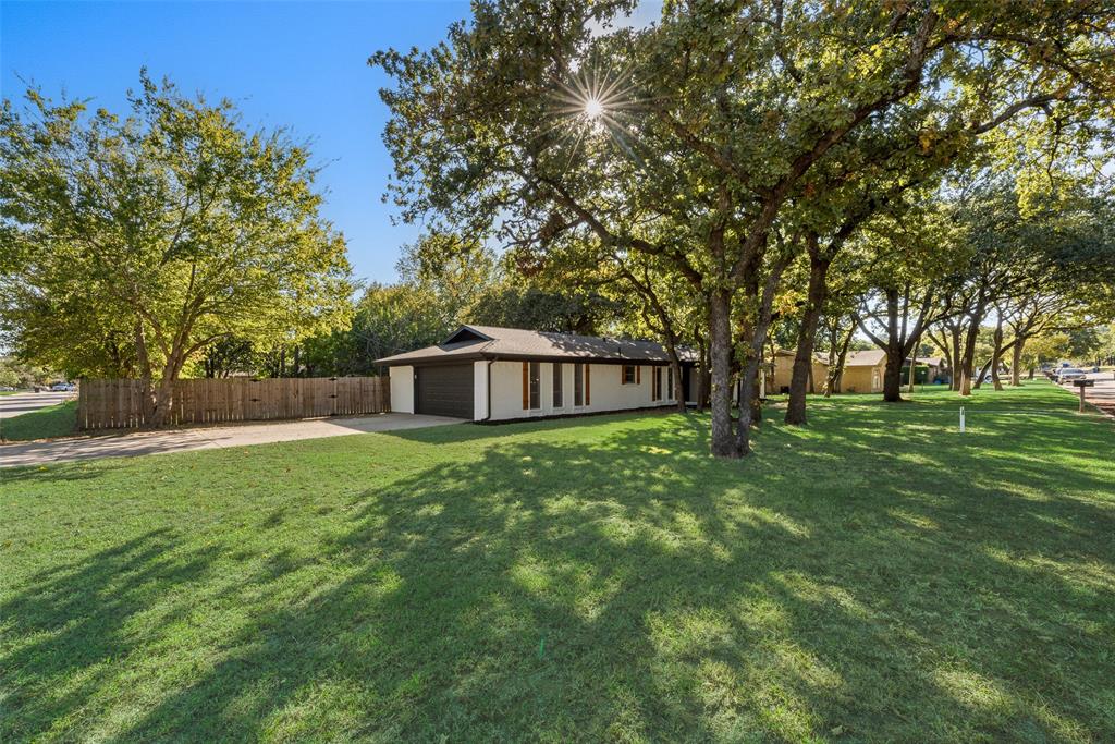 a view of a house with backyard and trees