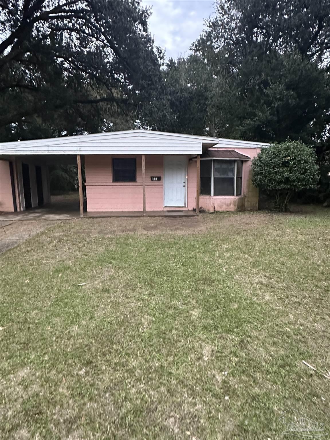 a front view of a house with yard and trees