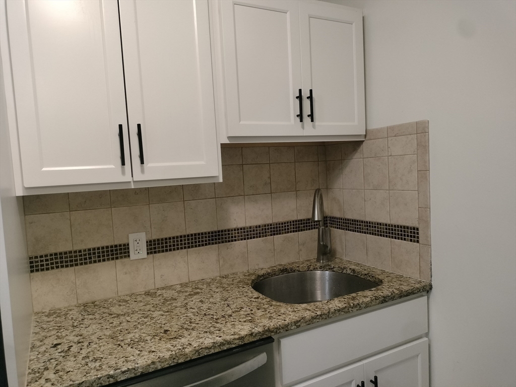 a kitchen with sink and cabinets