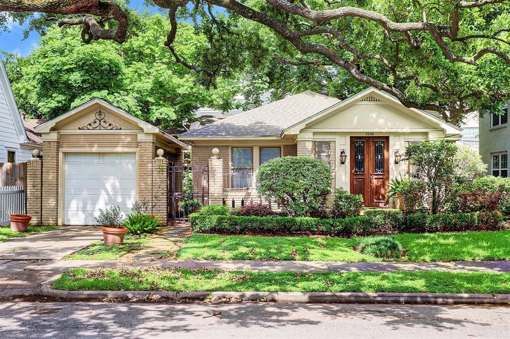 a front view of a house with a yard and potted plants